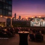 Rooftop employee appreciation movie night with Office Space on an inflatable screen